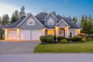 A large house with two garage doors and a driveway.